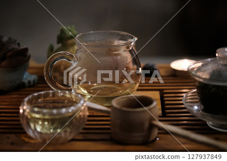 Traditional tea ceremony setup with glass teapot and cup Traditional tea ceremony setup with glass teapot and cup 127937849