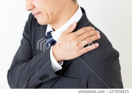 Middle-aged male businessman in a suit suffering from stiff shoulders 127938015