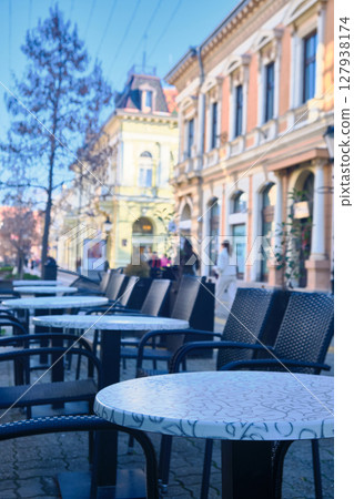 Empty outdoor cafe tables on European street Empty outdoor cafe tables on European street 127938174
