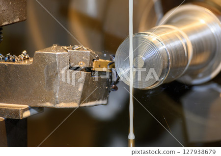 The lathe machine finish cut metal shaft parts with liquid coolant method. 127938679