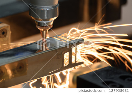 Close up scene the fiber laser cutting machine cut the square shape stainless steel tube with sparkling light. 127938681