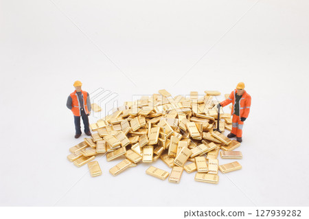 Miniature Workers Surrounding a Pile of Golden Bars Miniature Workers Surrounding a Pile of Golden Bars 127939282