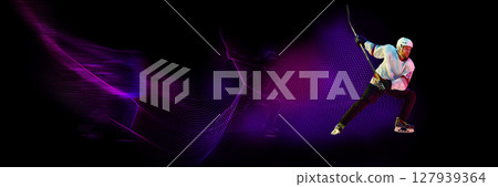 Hockey player in high-speed neon motion, strike pose with glowing trail, power and precision. Banner 127939364