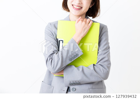 一位身著西裝的中年婦女拿著文件微笑 一位身著西裝的中年婦女拿著文件微笑 127939432