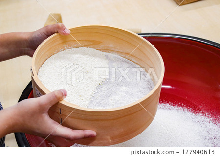 Child sifting buckwheat flour (7 years old/boy) 127940613