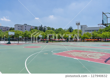University campus basketball court under blue sky and white clouds University campus basketball court under blue sky and white clouds 127940632