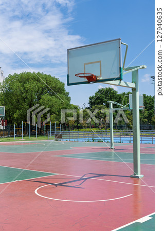 University campus basketball court under blue sky and white clouds University campus basketball court under blue sky and white clouds 127940635