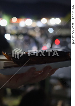 在小吃攤買的烤魷魚，背景是夜景 127940663