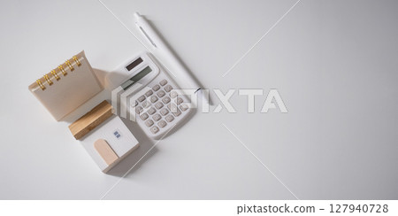 Home loan interest payment appointment. Calendar, house model, calculator and pen on the white table with copy space. 127940728
