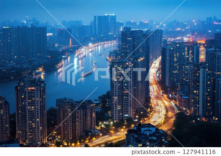 City Lights Reflect on River at Night with Busy Roads and Urban Skyline. Nightlife Cityscape. 127941116