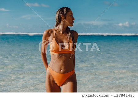 Summer portrait of tanned woman in swimwear at ocean beach. Summer portrait of tanned woman in swimwear at ocean beach. 127941485