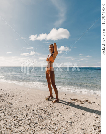 Gorgeous woman in bikini with tanned body posing on sea beach. 127941488