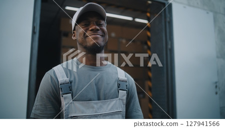 Logistics Retail Warehouse: Employee Giving Cardboard Box to Loader, Looking at Camera 127941566