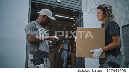 Diverse Employees Carrying Cardboard Boxes to Logistics Warehouse. Coordinator Scanning Parcels 127941598