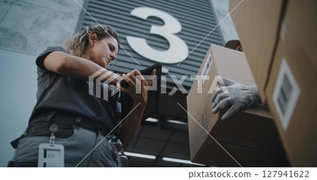 Multiethnic Workers Taking Cardboard Boxes. Female Manager Scanning Parcels, Using Tablet 127941622