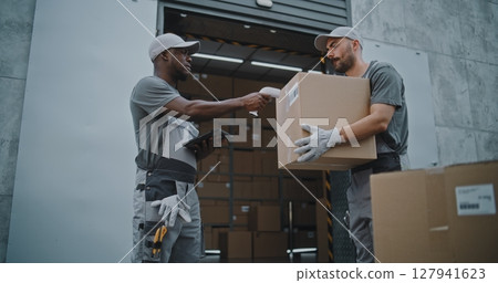 Workers Taking Cardboard Boxes to Logistics Retail Warehouse. Manager Scanning Parcels 127941623