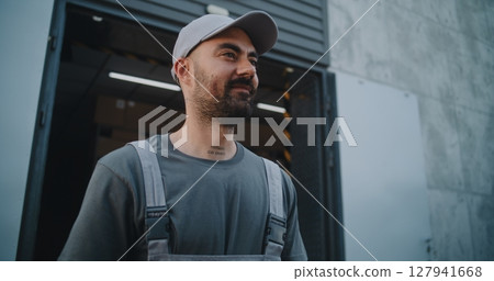 Logistics Warehouse: Worker Giving Cardboard Box to Unrecognizable Colleague for Delivery Logistics Warehouse: Worker Giving Cardboard Box to Unrecognizable Colleague for Delivery 127941668