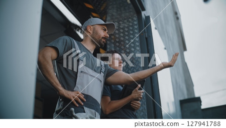 Male Employee and Female Manager with Digital Tablet Standing near Warehouse, Giving Directions Male Employee and Female Manager with Digital Tablet Standing near Warehouse, Giving Directions 127941788