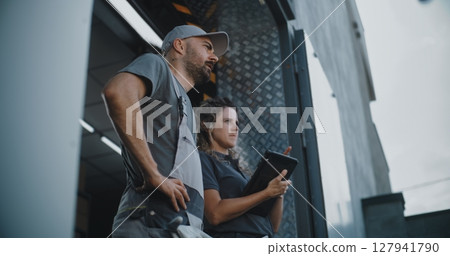 Male Employee and Female Manager with Digital Tablet Standing near Warehouse, Giving Directions Male Employee and Female Manager with Digital Tablet Standing near Warehouse, Giving Directions 127941790