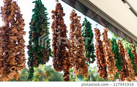 Colorful dried fruits hanging in bright market showcasing natural healthy food and decor elements 127941916