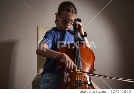 Young Musician Playing the Cello in Focused Practice Session 127941960