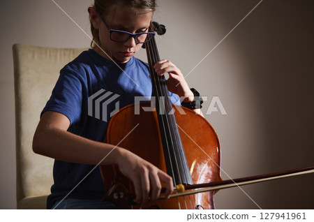 Young Musician Practicing Playing the Cello in a Quiet Setting Young Musician Practicing Playing the Cello in a Quiet Setting 127941961
