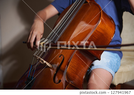 Close-Up of Person Playing the Cello in a Well-Lit Room 127941967