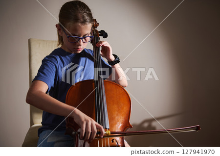 Young Musician Playing the Cello in a Studio Setting 127941970