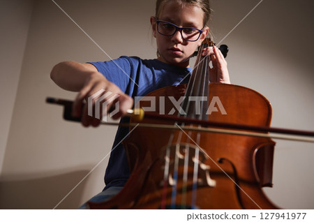 Young Musician Practicing Cello Performance in Well-Lit Room Young Musician Practicing Cello Performance in Well-Lit Room 127941977
