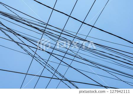 Tangled Overhead Utility Wires Crisscross Against a Clear Blue Sky in Urban Vietnam Tangled Overhead Utility Wires Crisscross Against a Clear Blue Sky in Urban Vietnam 127942111