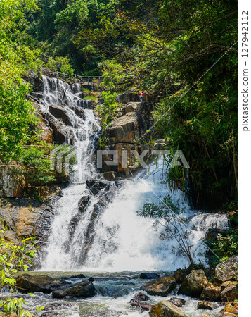 Majestic Datanla Waterfall cascades through lush forest rocks in Da Lat, a serene Vietnamese escape 127942112