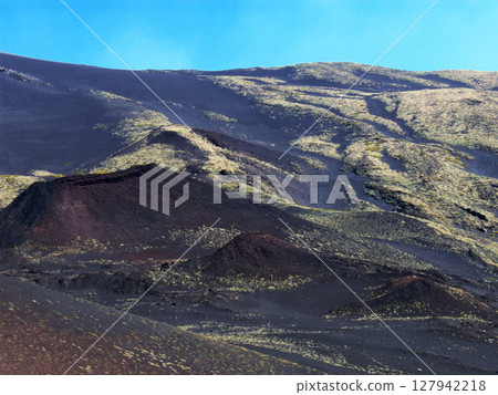 Majestic view of Mount Etna's volcanic landscape in Sicily, where the rugged terrain is illuminated by the warm hues of the setting sun.This breathtaking panorama captures the raw beauty. Majestic view of Mount Etna's volcanic landscape in Sicily, where the rugged terrain is illuminated by the warm hues of the setting sun.This breathtaking panorama captures the raw beauty. 127942218