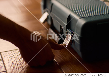 Hands skillfully opening a professional tool case designed specifically for high-quality equipment Hands skillfully opening a professional tool case designed specifically for high-quality equipment 127942532