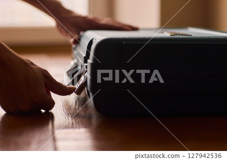 Hands skillfully opening a professional tool case designed specifically for high-quality equipment Hands skillfully opening a professional tool case designed specifically for high-quality equipment 127942536