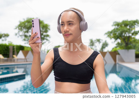 Non-binary person exercising in poolside doing yoga and wearing sport bra Non-binary person exercising in poolside doing yoga and wearing sport bra 127943005