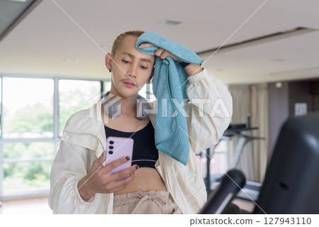 Non-binary person exercising in gym wearing sportswear Non-binary person exercising in gym wearing sportswear 127943110
