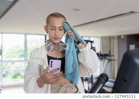 Non-binary person exercising in gym wearing sportswear Non-binary person exercising in gym wearing sportswear 127943111