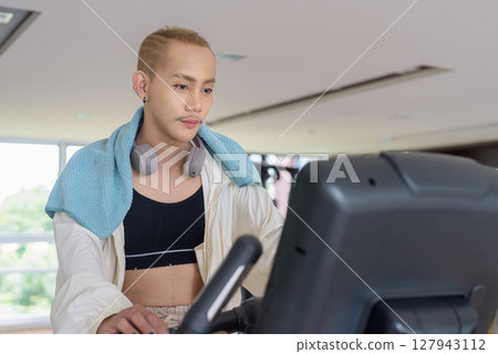 Non-binary person exercising in gym wearing sportswear Non-binary person exercising in gym wearing sportswear 127943112