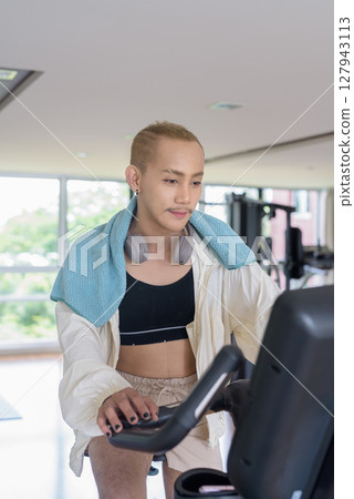 Non-binary person exercising in gym wearing sportswear 127943113
