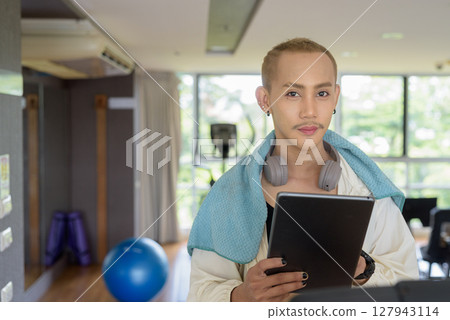Non-binary person exercising in gym wearing sportswear Non-binary person exercising in gym wearing sportswear 127943114