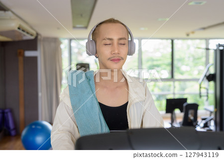 Non-binary person exercising in gym wearing sportswear Non-binary person exercising in gym wearing sportswear 127943119