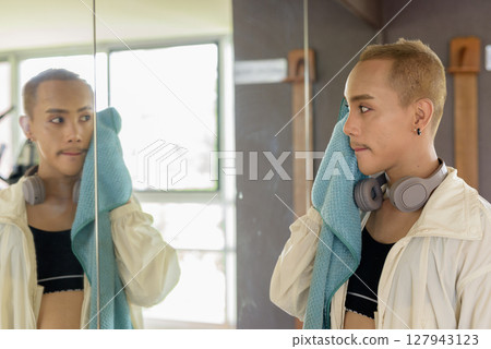 Non-binary person exercising in gym wearing sportswear Non-binary person exercising in gym wearing sportswear 127943123
