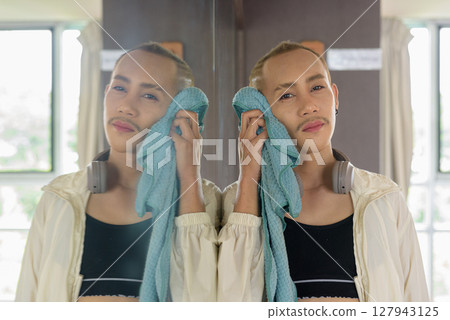 Non-binary person exercising in gym wearing sportswear 127943125
