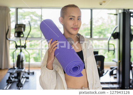 Non-binary person exercising in gym wearing sportswear 127943126