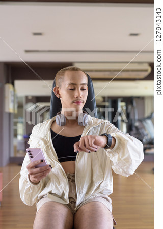 Non-binary person exercising in gym wearing sportswear 127943143
