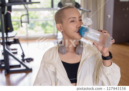 Non-binary person exercising in gym wearing sportswear Non-binary person exercising in gym wearing sportswear 127943156