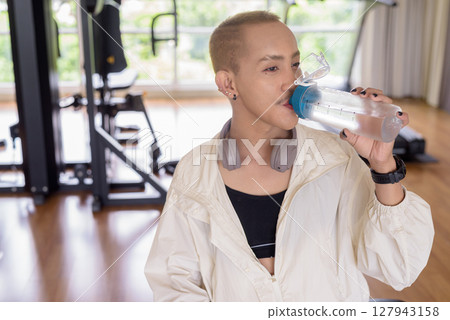 Non-binary person exercising in gym wearing sportswear 127943158
