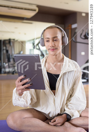 Non-binary person exercising in gym wearing sportswear Non-binary person exercising in gym wearing sportswear 127943189