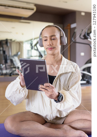 Non-binary person exercising in gym wearing sportswear Non-binary person exercising in gym wearing sportswear 127943190