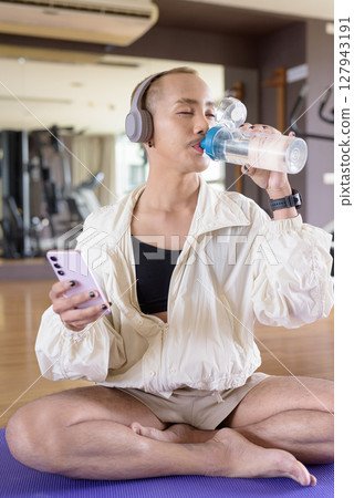 Non-binary person exercising in gym wearing sportswear 127943191
